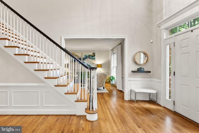 12019 Wandabury Rd, Oakton, VA 22124 - foyer with stairs, a towering ceiling, a wainscoted wall, light wood-type flooring, and a decorative wall