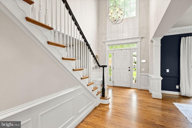 12019 Wandabury Rd, Oakton, VA 22124 - foyer with a high ceiling, a decorative wall, stairway, light wood-style flooring, and a wainscoted wall