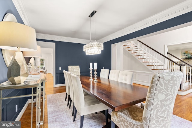 12019 Wandabury Rd, Oakton, VA 22124 - dining space with stairway, a chandelier, wood finished floors, crown molding, and a decorative wall