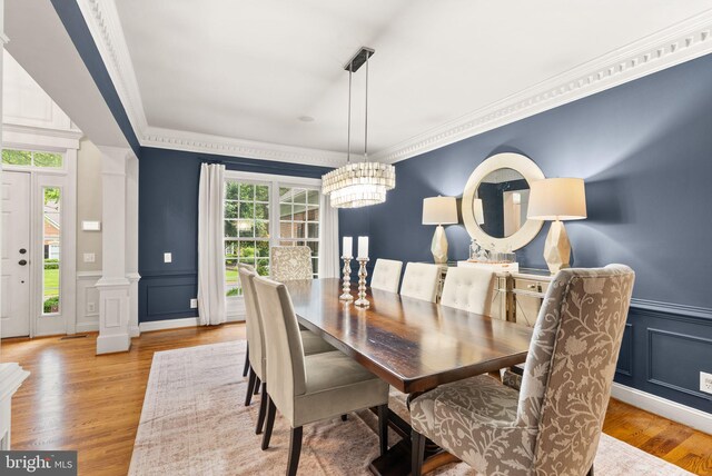 12019 Wandabury Rd, Oakton, VA 22124 - dining room featuring a decorative wall, a chandelier, wood finished floors, crown molding, and ornate columns