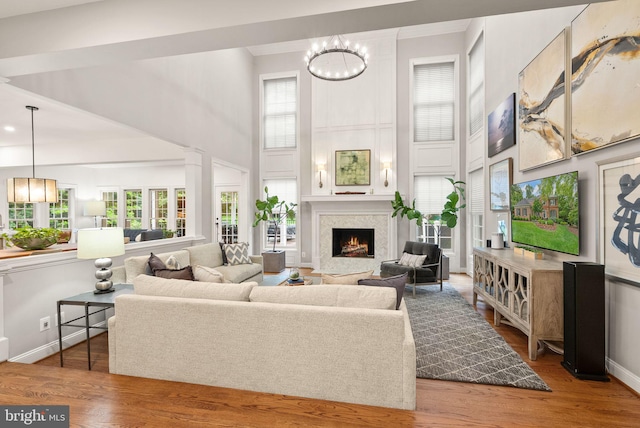 12019 Wandabury Rd, Oakton, VA 22124 - living area with healthy amount of natural light, a high ceiling, a fireplace, and wood finished floors