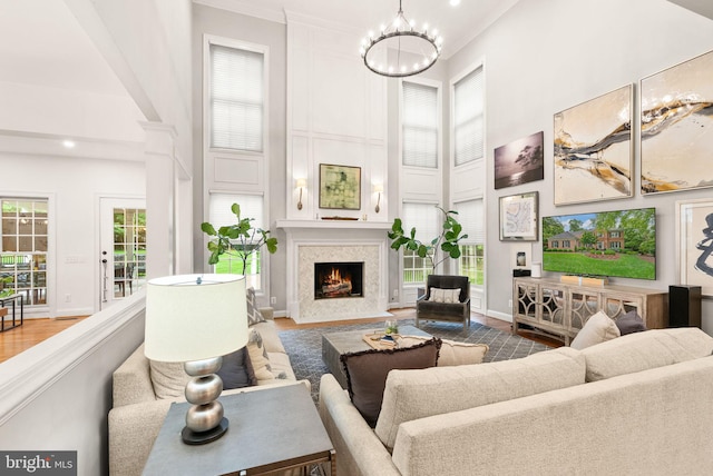 12019 Wandabury Rd, Oakton, VA 22124 - living room featuring a high ceiling, a chandelier, a fireplace with flush hearth, baseboards, and ornate columns