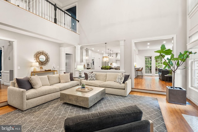 12019 Wandabury Rd, Oakton, VA 22124 - living area with decorative columns, wood finished floors, a high ceiling, and recessed lighting