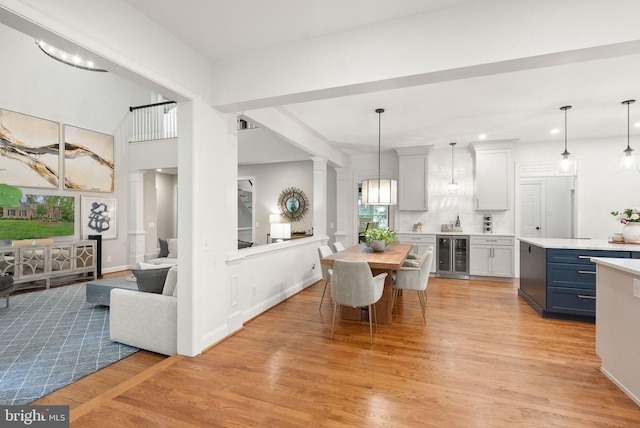 12019 Wandabury Rd, Oakton, VA 22124 - dining space featuring wine cooler, light wood-style floors, recessed lighting, and ornate columns