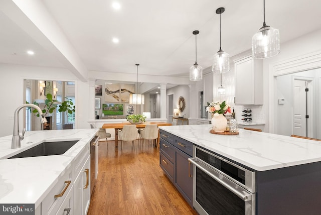 12019 Wandabury Rd, Oakton, VA 22124 - kitchen with a sink, appliances with stainless steel finishes, white cabinetry, light wood finished floors, and recessed lighting