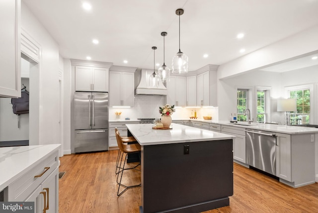 12019 Wandabury Rd, Oakton, VA 22124 - kitchen with stainless steel appliances, a sink, premium range hood, a peninsula, and tasteful backsplash