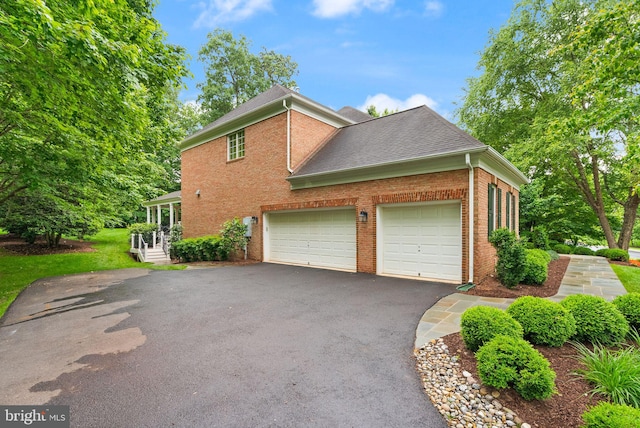 12019 Wandabury Rd, Oakton, VA 22124 - view of home's exterior with brick siding, asphalt driveway, an attached garage, and roof with shingles
