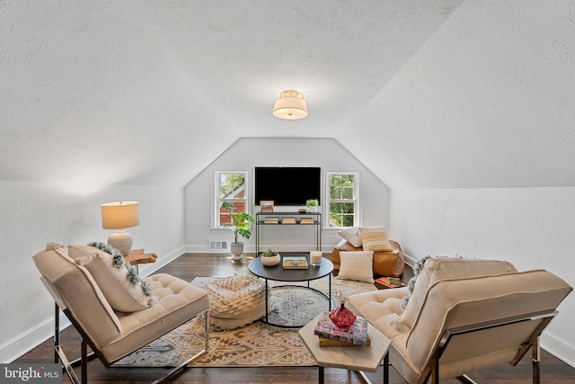 living room with baseboards, vaulted ceiling, a textured ceiling, and visible vents