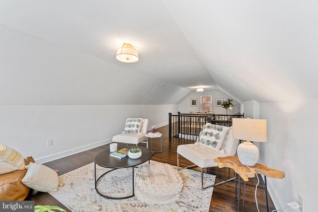 sitting room featuring baseboards, wood finished floors, and lofted ceiling