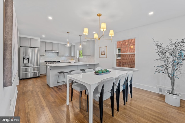 dining room featuring recessed lighting, baseboards, visible vents, and wood finished floors