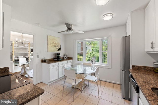 kitchen with ceiling fan with notable chandelier, baseboards, white cabinetry, dark stone countertops, and appliances with stainless steel finishes