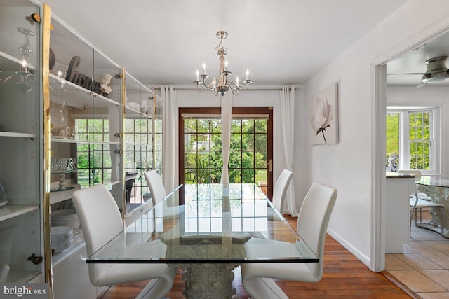 dining room featuring baseboards, a notable chandelier, a wealth of natural light, and wood finished floors
