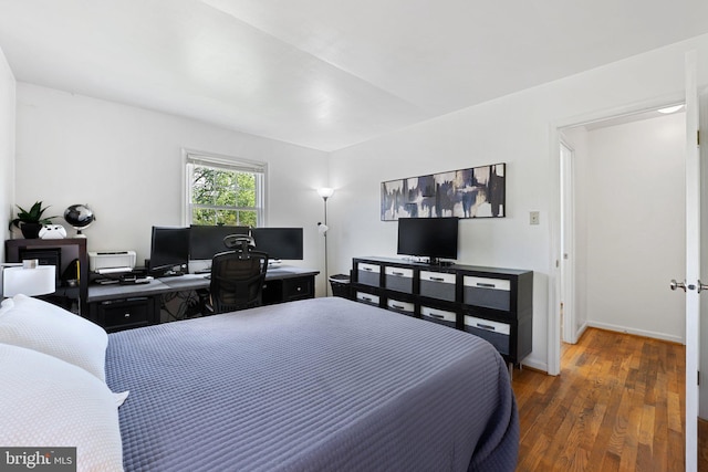 bedroom with baseboards and wood finished floors