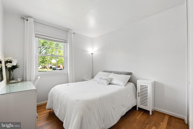 bedroom featuring baseboards and wood finished floors
