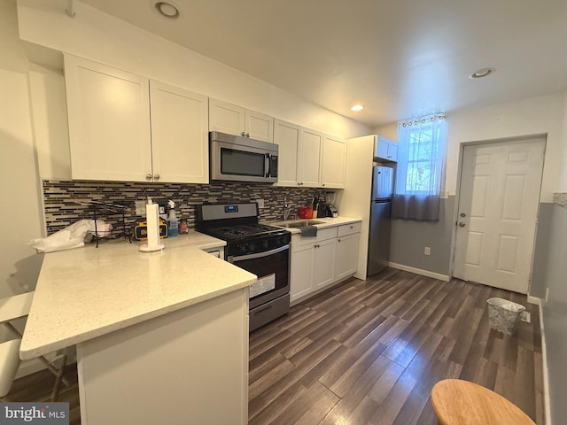 653 N 37th St, Philadelphia, PA 19104 - kitchen featuring white cabinets, backsplash, stainless steel appliances, and a peninsula