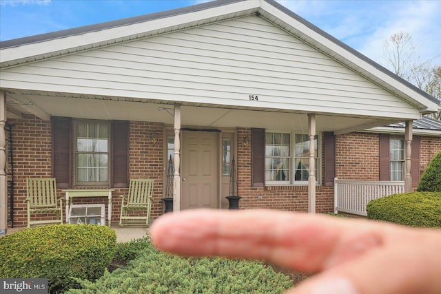 view of front of home with a porch and brick siding