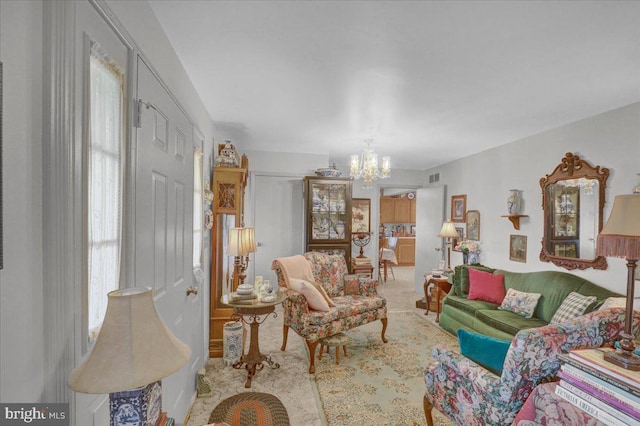 living room with an inviting chandelier, a wealth of natural light, and visible vents