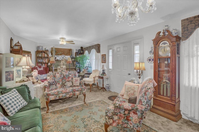 living area featuring carpet floors and ceiling fan with notable chandelier