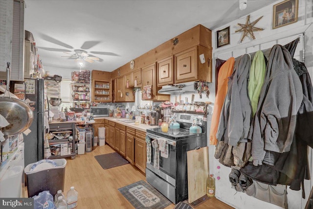 kitchen featuring a sink, ceiling fan, stainless steel appliances, and light wood-type flooring
