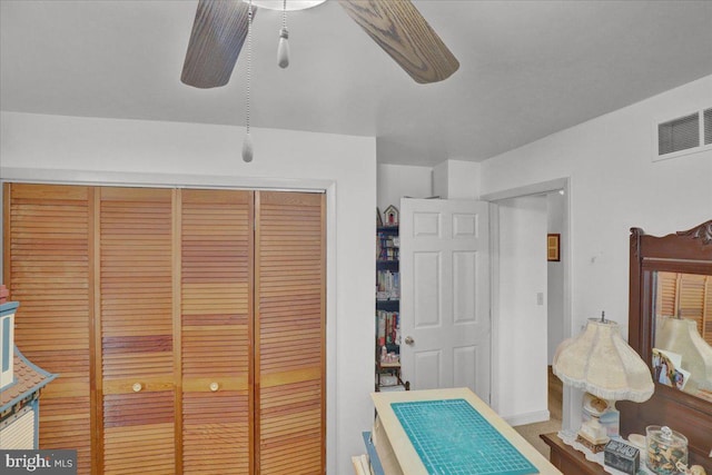 bedroom with ceiling fan, visible vents, and a closet