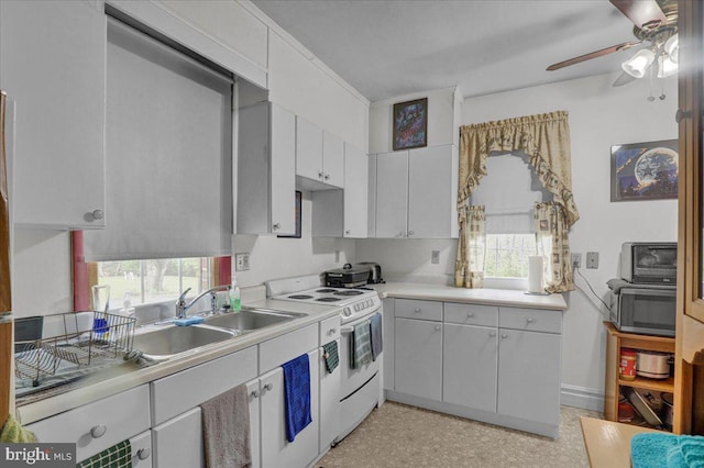 kitchen with white electric range oven, ceiling fan, light countertops, white cabinetry, and stainless steel microwave