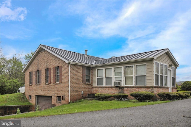 view of home's exterior with brick siding, central air condition unit, and a standing seam roof