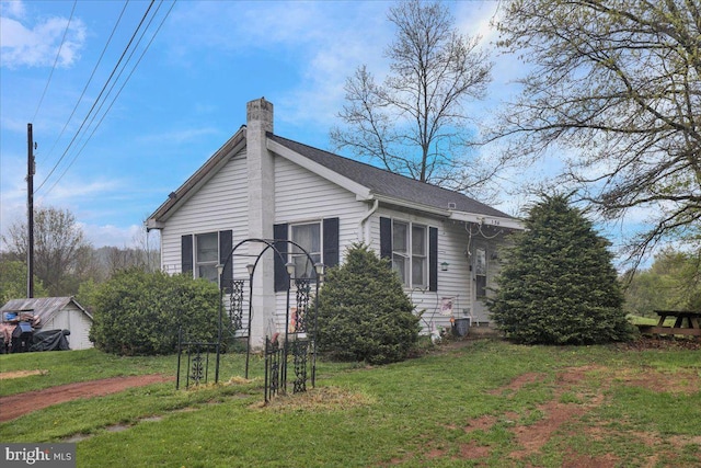 view of front of house featuring a chimney and a front yard