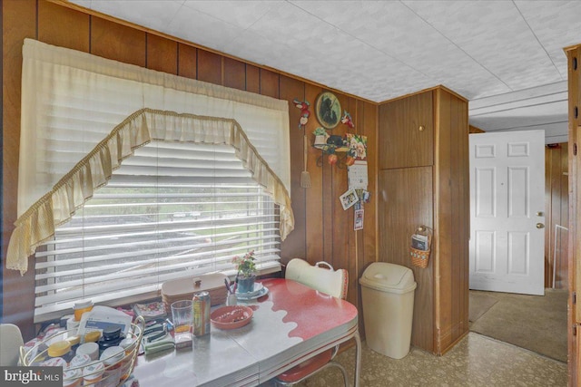 dining area with wooden walls and tile patterned floors