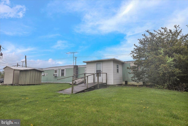 back of house with a lawn, an outdoor structure, and a shed