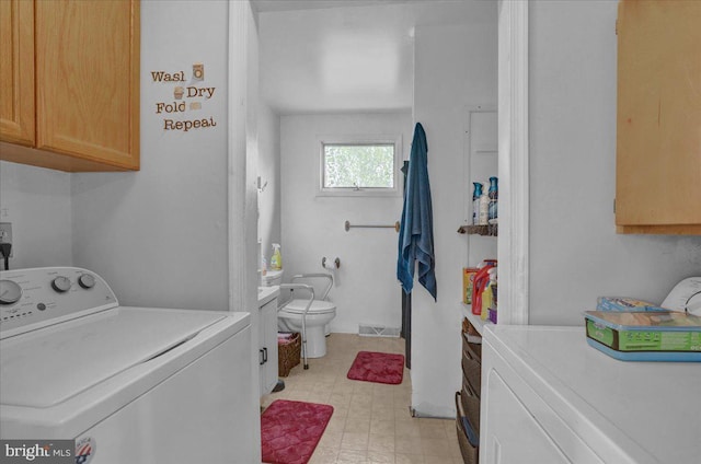 clothes washing area featuring independent washer and dryer, cabinet space, and visible vents