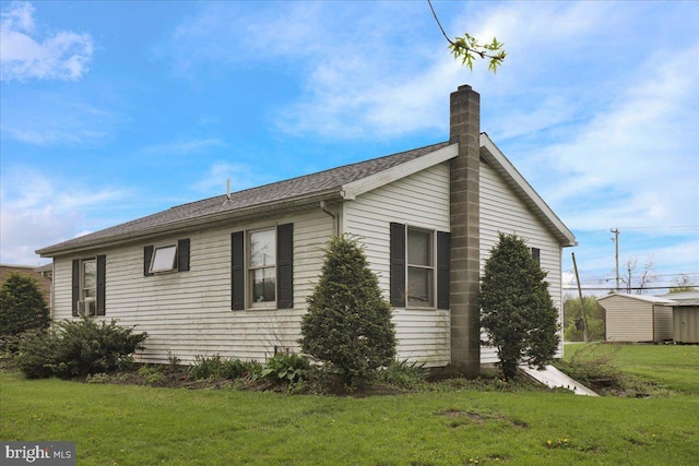 view of side of property featuring a yard and a chimney