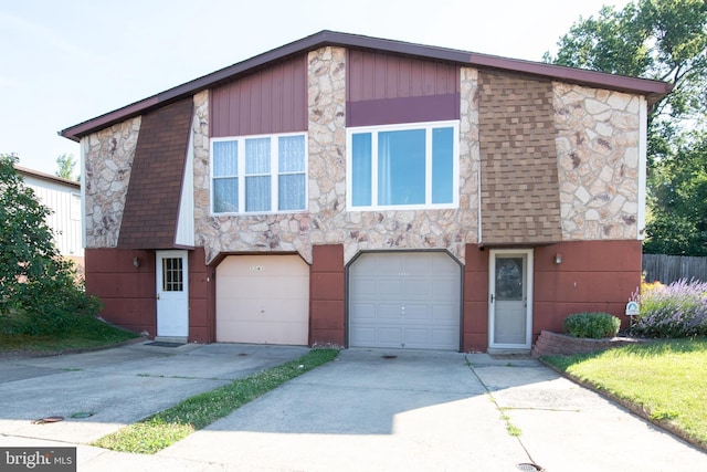 view of front of property with a garage, concrete driveway, and stone siding