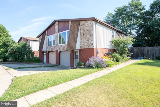 view of home's exterior featuring a garage, fence, stone siding, a lawn, and driveway