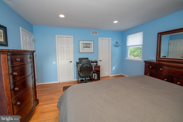 bedroom with baseboards, recessed lighting, light wood-style flooring, and visible vents