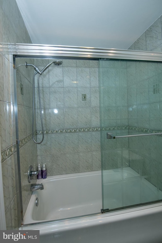 bathroom featuring combined bath / shower with glass door