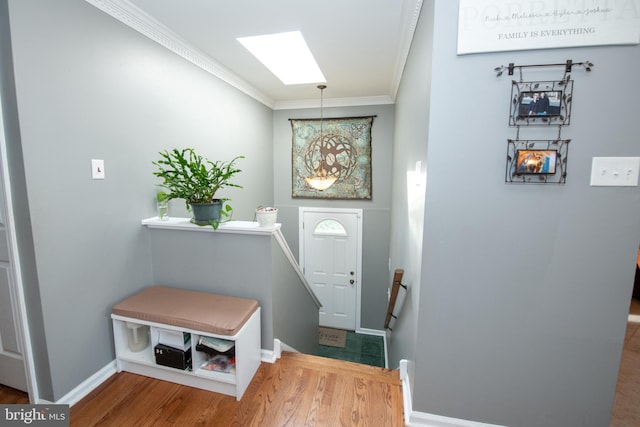 interior space featuring baseboards, ornamental molding, and wood finished floors