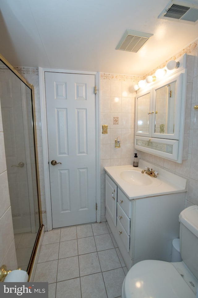 bathroom with visible vents, toilet, and tile walls