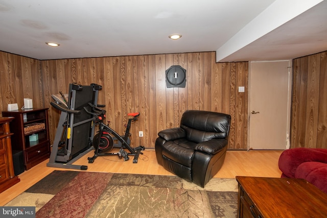 exercise area featuring wood finished floors and wooden walls