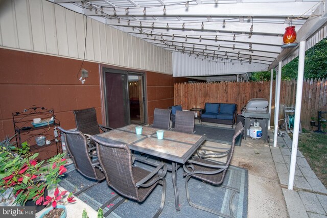 view of patio with grilling area, a pergola, fence, and outdoor dining space