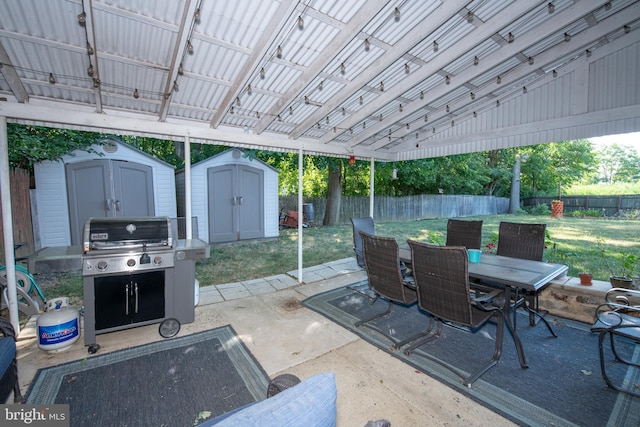 view of patio / terrace featuring an outbuilding, outdoor dining space, a fenced backyard, and a storage unit