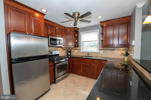 kitchen with ceiling fan, appliances with stainless steel finishes, open shelves, a sink, and dark stone counters