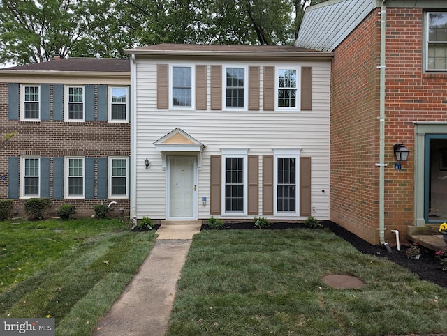 townhome / multi-family property featuring a front lawn and brick siding
