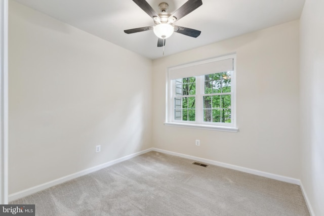 carpeted spare room with baseboards and a ceiling fan