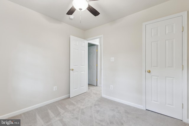 unfurnished bedroom with light carpet, baseboards, and a ceiling fan