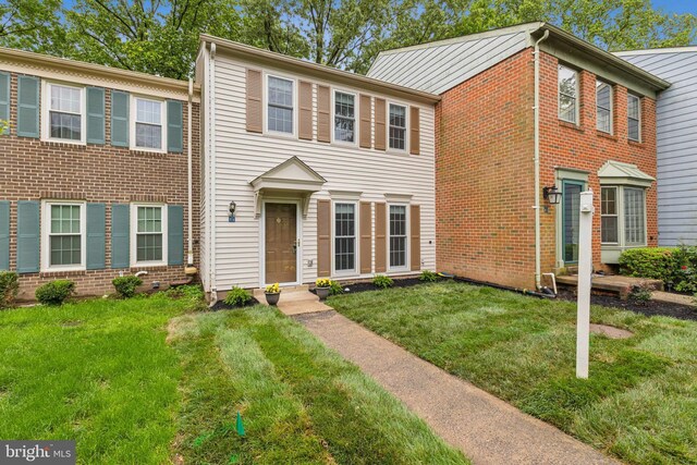 view of front of house featuring a front lawn and brick siding
