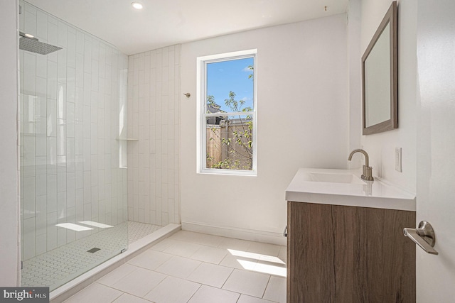 bathroom with vanity, tile patterned floors, recessed lighting, baseboards, and tiled shower