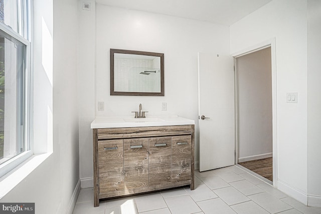 bathroom with vanity, tile patterned flooring, and baseboards