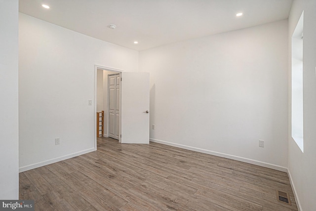 empty room featuring recessed lighting, baseboards, visible vents, and wood finished floors
