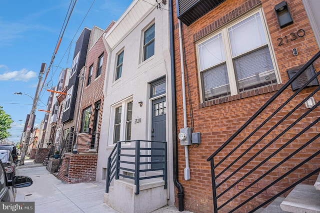view of exterior entry featuring brick siding