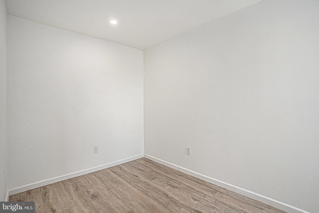 empty room with light wood-style floors, baseboards, and recessed lighting